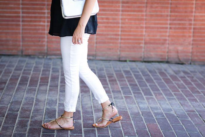 gold and black sandals and white jeans